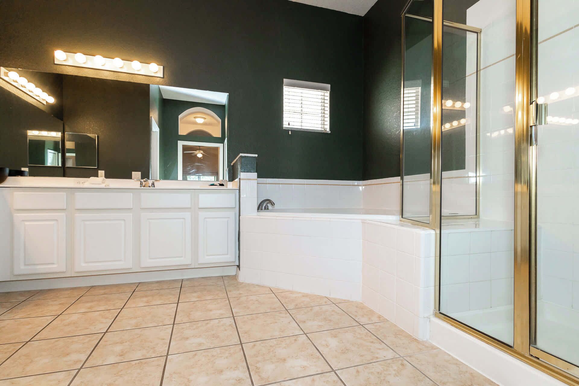A modern bathroom with a large vanity, a bathtub, and a walk-in shower.