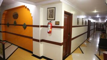 A hotel corridor with a fire extinguisher, a door marked "2nd Floor," and a framed picture on the wall.