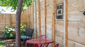 A wooden fence with a sign that reads "RELAX AND UNWIND." - Mid-City Bungalow, 1 Mile from Bathhouse Row, Pup Friendly, Fully Fenced Yard! (Hot Springs)