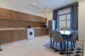 Deluxe suite | Privékeuken | Een koelkast met diepvriezer, een microgolfoven, een oven