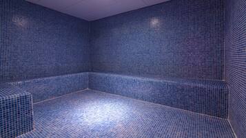 Guest rooms feature a geometric patterned floor and walls, with recessed lighting and a flat ceiling.