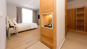 Una habitación de hotel moderna con cama, mesita de noche y armario empotrado.