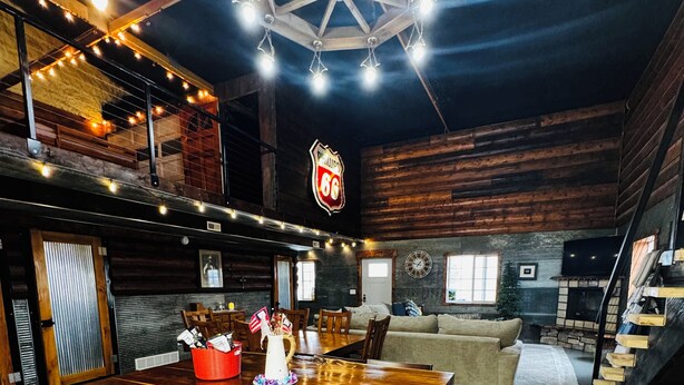A rustic interior with a wooden bar, seating area, and a large clock on the wall. - New Rustic Retreat, Firepit & Games, Hiking, Boating & Fishing near Lake Rathbun (Moravia)