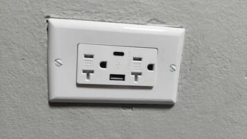 A white electrical outlet on a textured wall.