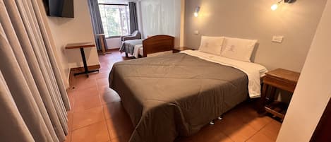 Un dormitorio con cama, escritorio y silla.