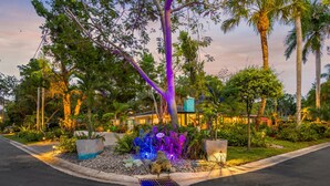 A landscaped garden with a variety of plants and a building in the background. - Salty Lime Villa 2-Riverview w/pool on riverwalk, near AMI beaches, pet friendly (Bradenton)