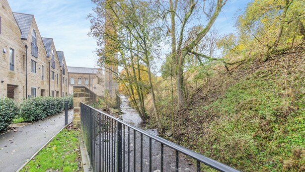 A stone building with a river running alongside. - 1 bedroom accommodation in Haworth (Haworth)
