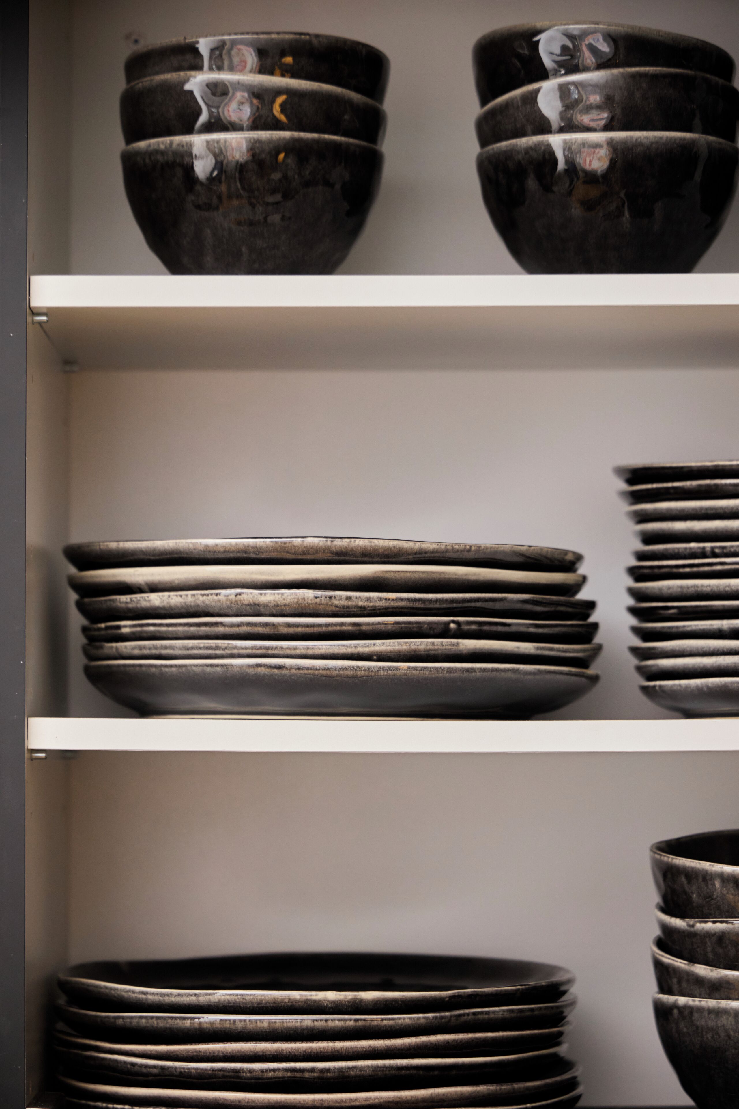 A display of stacked bowls and plates on shelves.