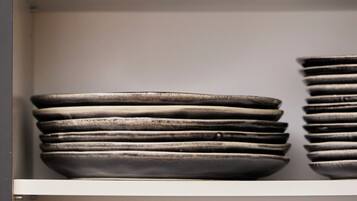A display of stacked bowls and plates on shelves.