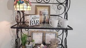 Un coin café aménagé avec un panneau, une machine à café, des tasses et des récipients pour la nourriture des animaux de compagnie.