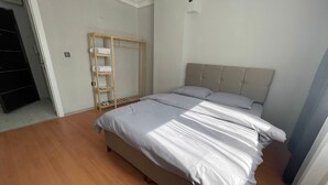 A bedroom with a bed, a wooden shelf unit, and a wardrobe. - Konak Suite Ankara (Ankara)