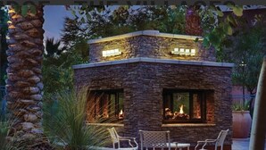 A stone building with a fireplace, surrounded by outdoor seating and plants. - Excellent retreat near Coachella Valley festival (Palm Desert)