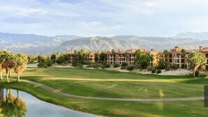 A golf course with a pond, palm trees, and a mountain backdrop. - Excellent retreat near Coachella Valley festival (Palm Desert)