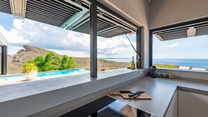Una cocina moderna con vista al océano y una piscina.