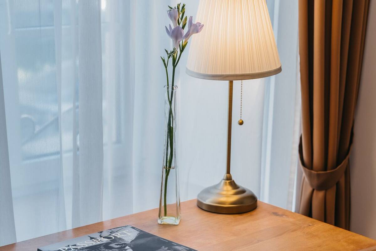 A wooden desk with a lamp, a vase with flowers, and a book titled "PASSION".