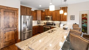 Una cocina moderna con armarios de madera, electrodomésticos de acero inoxidable y encimera de mármol.