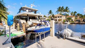 A marina with boats docked, a covered area, and a waterfront property with palm trees. - Waterfront Oasis - Saltwater Pool - Kayaks - Minutes to Fort Lauderdale Beach! (Fort Lauderdale)