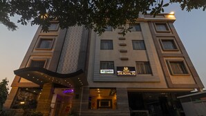 A hotel with a modern design, featuring a prominent entrance with a glass facade and a sign for 'The Royal Taj'. - Treebo The Royal Taj (Agra)