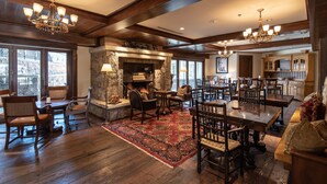 A spacious living area with a stone fireplace, wooden furniture, and large windows. - Cozy retreat at One Willow Bridge Road in Vail Village (Vail)