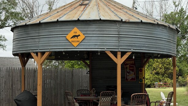 A gazebo with a 'Fox Crossing' sign, outdoor seating, and a barbecue grill. - Cozy up at Foxtrot Inn! 
Immaculate! Outdoor Grain Bin BBQ area! Dog friendly!  (Cunningham)