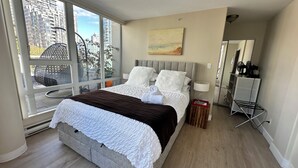 A modern bedroom with a large bed, a view of the city through floor-to-ceiling windows, and a minimalist decor. - Penthouse with Large Deck on Seawall / Beach w/ Views (Vancouver)