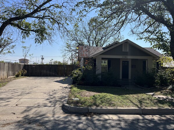 A residential house with a garage, a fenced yard, and a clear sky. - Stockyards ,Dickies, Cowtown Coliseum, 7th Street Close to All !! (Fort Worth)