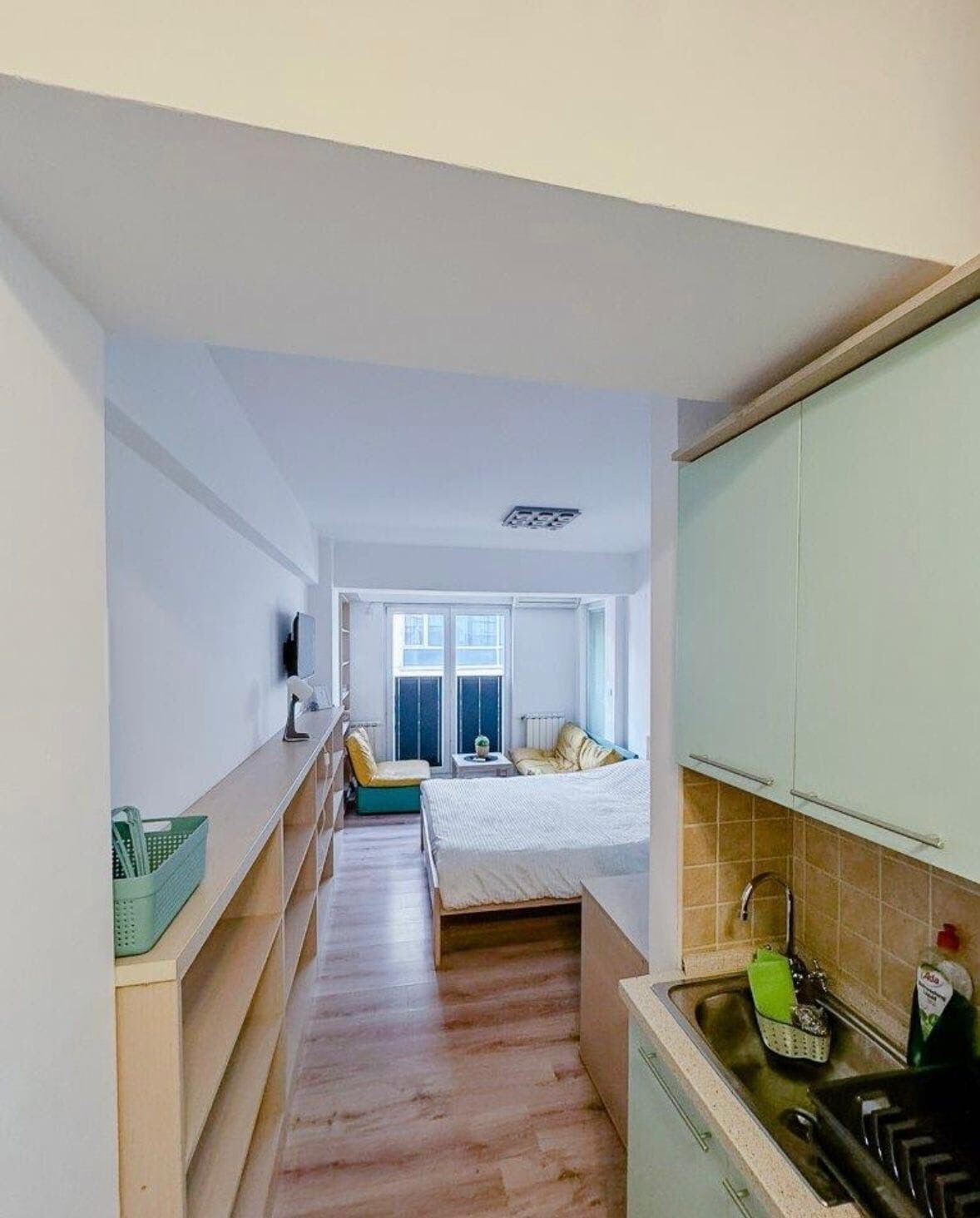 Een compact appartement met kitchenette, een klein eethoekje, een bed en een raam met uitzicht.