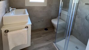 A bathroom with a shower, a sink, and a toilet.