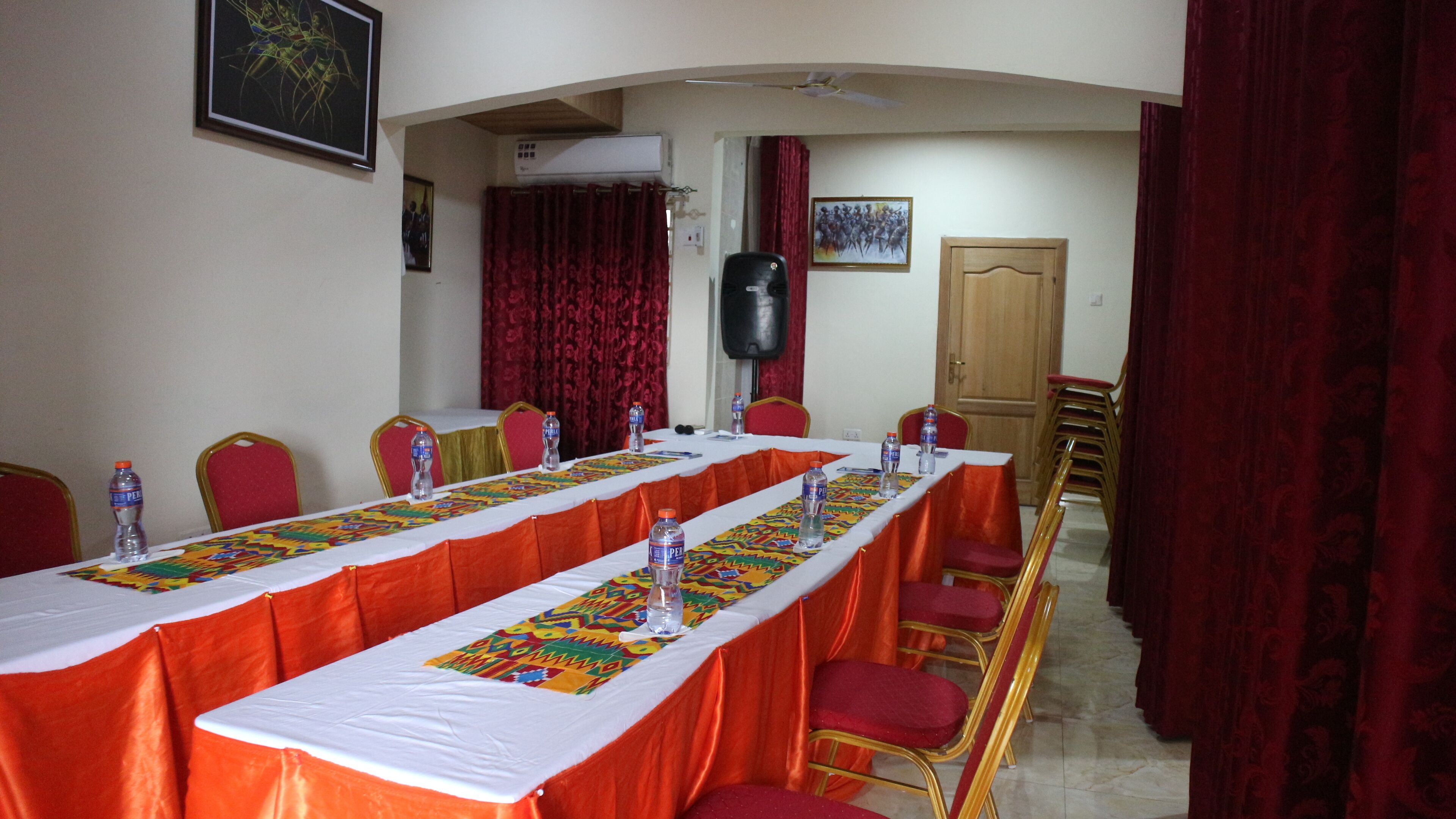 A conference room with a long table, chairs, and a speaker system.