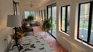 A room with a long table, chairs, a lamp, and large windows. - Cozy Cabin Natural Bridge VA (Natural Bridge Station)