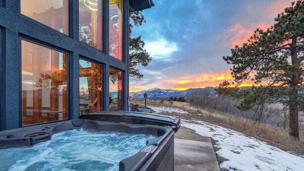 A hot tub outside a building with a mountain view.