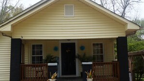 A single-story house with a front porch, a black front door, and two potted plants on the steps. - Beautiful contemporary 2BDR - Concord (Concord)