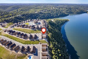 An aerial view of a lakeside resort with multiple buildings, a parking lot, and a red location marker. - Lake View Retreat with Indoor Pool, Theatre, Game Room & Free Daily Tickets (Kimberling City)