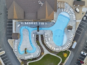 An aerial view of a swimming pool complex with multiple lanes, a deck area, and a parking lot. - Lake View Retreat with Indoor Pool, Theatre, Game Room & Free Daily Tickets (Kimberling City)