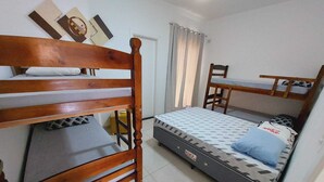 A bedroom with two bunk beds, a single bed, a chair, and a small table. - Sabe Aquele Lugar Tranquilo e Lindo?! Assim é a Casa de Temporada Analu (Olímpia)