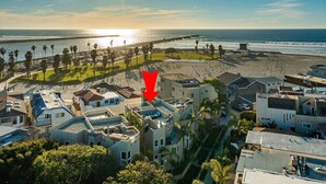 Ein Küstenwohngebiet mit modernen Häusern, einem Strand und einem Steg.