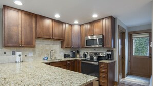 A kitchen with granite countertops, wooden cabinets, stainless steel appliances, and a built-in oven. - Ski Hill Ridge on Peak 7 with Epic Views! (Breckenridge)