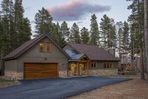 A two-story house with a stone foundation, a large garage, and a deck. - Ski Hill Ridge on Peak 7 with Epic Views! (Breckenridge)