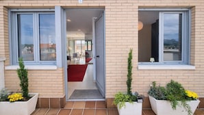 Una casa moderna de dos pisos con un espacio habitable visible, un sofá rojo y un comedor.