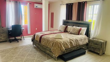 A bedroom with a bed, a desk, and a chair.