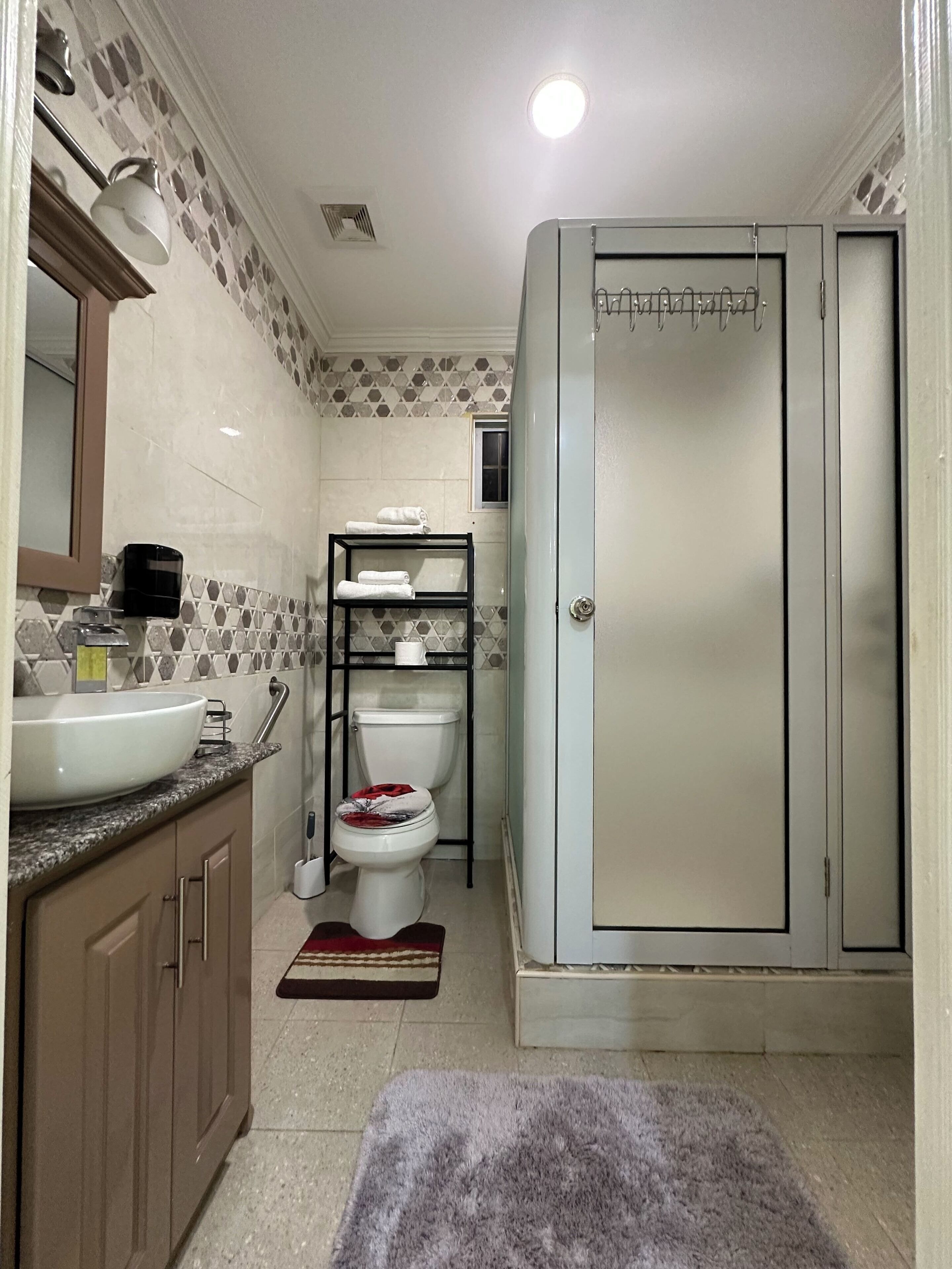 A bathroom with a sink, toilet, and shower.