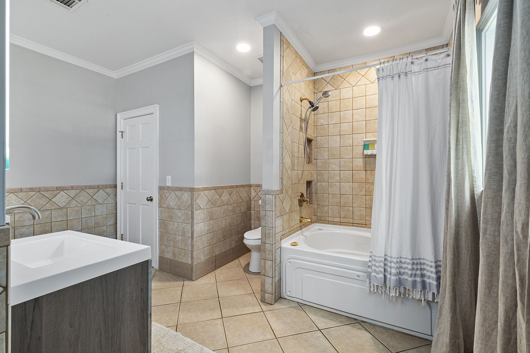A bathroom with a bathtub, a shower, a toilet, and a sink.