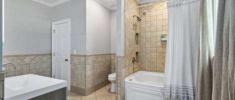 A bathroom with a bathtub, a shower, a toilet, and a sink.