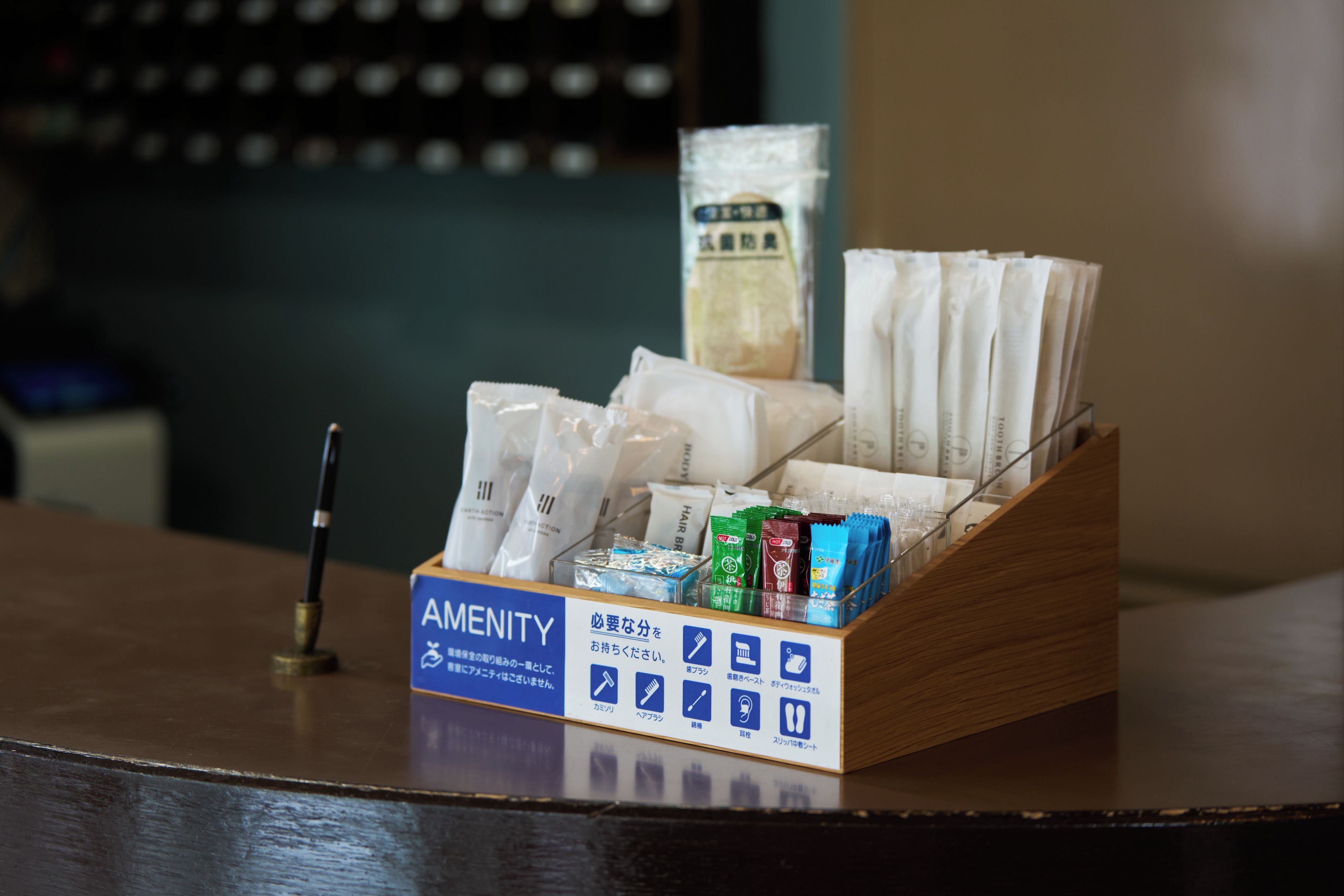 A hotel reception desk with a sign indicating amenities.