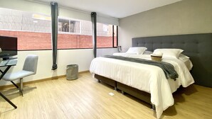 A modern bedroom with a bed, a desk, and a chair. - Apartamento,5 Parque de la 93 (Bogotá)