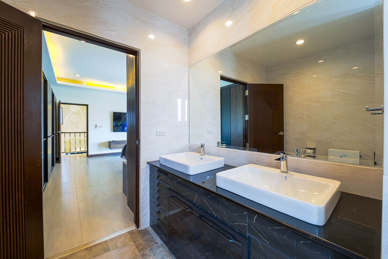 A modern bathroom with two sinks, a large mirror, and a walk-in shower.