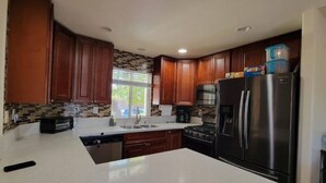 Una cocina moderna con armarios de madera, un refrigerador de acero inoxidable y una isla grande.