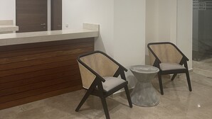 A reception area with two chairs, a counter, and a ceiling fan.