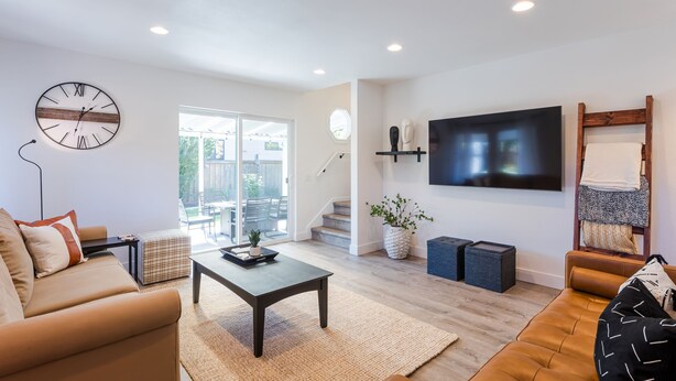 Un salon moderne avec un canapé, une table basse et un téléviseur fixé au mur.