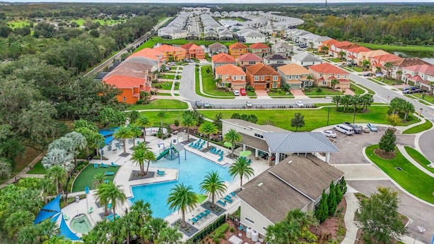 A residential area with a large swimming pool, multiple houses, and a well-maintained lawn. - Large 4-Bedroom 4-Bathroom Pool near attractions and Theme Parks (Kissimmee)